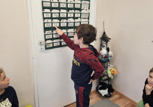 Na zdjęciu widać dziecko przy tablicy z literami.
