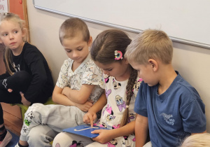 Na zdjęciu widać dziecko które pisze literę L po śladzie.