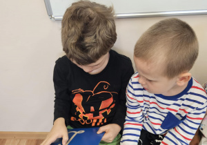 Na zdjęciu widać dziecko które pisze literę L po śladzie.