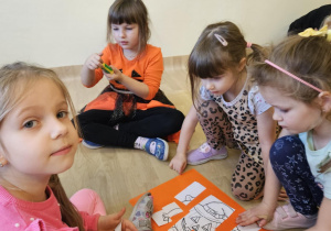 Na zdjęciu widać dzieci przy stoliku dzieci które robią prace plastyczną.