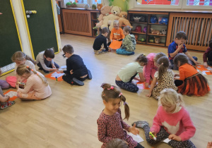 Na zdjęciu widać dzieci przy stoliku dzieci które robią prace plastyczną.