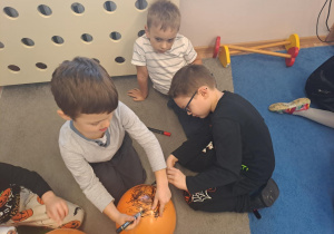 Na zdjęciu widać dzieci na dywanie które robią prace plastyczną.