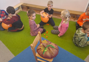 Na zdjęciu widać dzieci na dywanie które robią prace plastyczną.