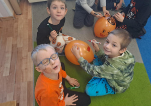 Na zdjęciu widać dzieci na dywanie które robią prace plastyczną.