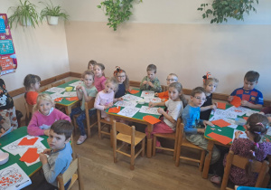Na zdjęciu widać dzieci przy stoliku dzieci które robią prace plastyczną.