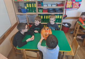 Na zdjęciu widać dzieci przy stoliku dzieci które robią prace plastyczną.