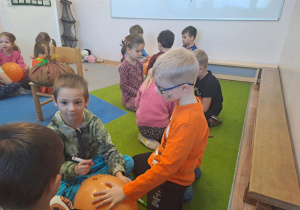 Na zdjęciu widać dzieci na dywanie które robią prace plastyczną.