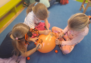 Na zdjęciu widać dzieci na dywanie które robią prace plastyczną.