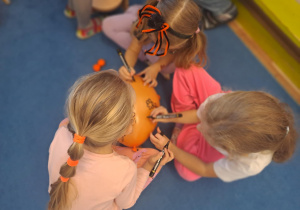 Na zdjęciu widać dzieci na dywanie które robią prace plastyczną.