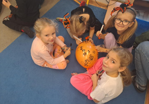 Na zdjęciu widać dzieci przy stoliku dzieci które robią prace plastyczną.