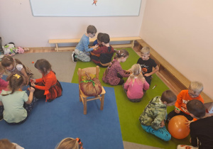 Na zdjęciu widać dzieci przy stoliku dzieci które robią prace plastyczną.