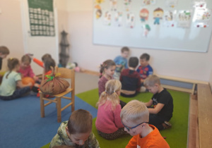 Na zdjęciu widać dzieci przy stoliku dzieci które robią prace plastyczną.