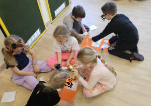 Na zdjęciu widać dzieci które robią prace plastyczną.