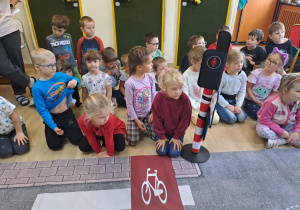 Na zdjęciu widać dzieci które uczą się przestrzegania zasad obowiązujących na ulicy.