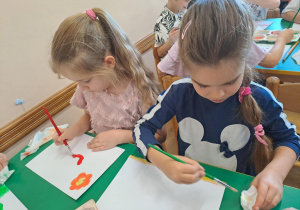 Na zdjęciu widać dzieci jak rysują kreatywną pracę plastyczną.