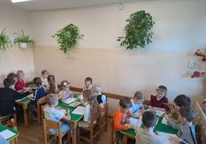 Na zdjęciu widać dzieci jak rysują kreatywną pracę plastyczną.