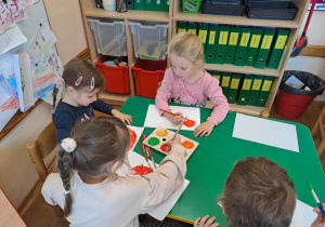 Na zdjęciu widać dzieci jak rysują kreatywną pracę plastyczną.