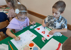 Na zdjęciu widać dzieci jak rysują kreatywną pracę plastyczną.
