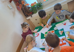 Na zdjęciu widać dzieci jak rysują kreatywną pracę plastyczną.