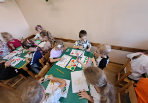 Na zdjęciu widać dzieci jak rysują kreatywną pracę plastyczną.
