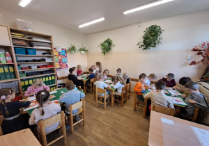 Na zdjęciu widać dzieci jak rysują kreatywną pracę plastyczną.
