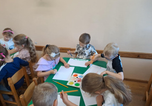 Na zdjęciu widać dzieci jak rysują kreatywną pracę plastyczną.