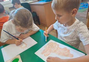 Na zdjęciu widać dzieci jak rysują kreatywną pracę plastyczną.