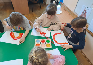 Na zdjęciu widać dzieci jak rysują kreatywną pracę plastyczną.