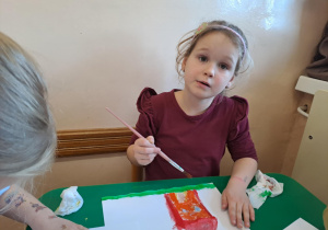 Na zdjęciu widać dzieci jak rysują kreatywną pracę plastyczną.