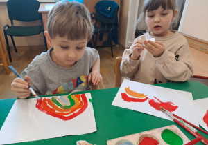 Na zdjęciu widać dzieci jak rysują kreatywną pracę plastyczną.