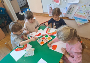 Na zdjęciu widać dzieci jak rysują kreatywną pracę plastyczną.