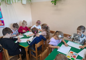 Na zdjęciu widać dzieci jak rysują kreatywną pracę plastyczną.