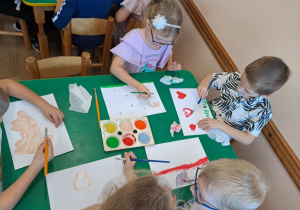 Na zdjęciu widać dzieci jak rysują kreatywną pracę plastyczną.