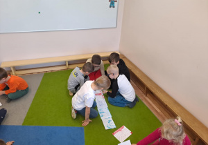 Na zdjęciu widać dzieci jak rysują kreatywną pracę plastyczną.