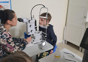 Na zdjęciu widać dzieci na warsztatach u okulisty.