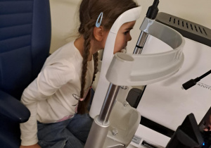 Na zdjęciu widać dzieci na warsztatach u okulisty.