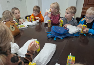 Na zdjęciu widać dzieci na warsztatach z dietetykiem. Dzieci jedzą kanapki.