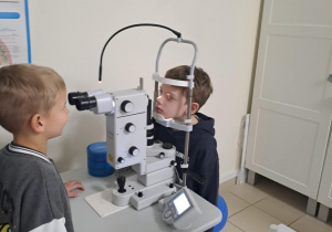 Na zdjęciu widać dzieci na warsztatach u okulisty.
