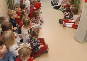 Na zdjęciu widać dzieci i Św Mikołaja który wręcza prezenty.