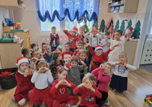 Na zdjęciu widać dzieci i Św Mikołaja który wręcza prezenty.