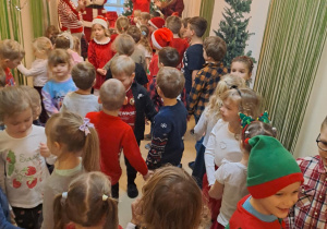 Na zdjęciu widać dzieci i Św Mikołaja który wręcza prezenty.