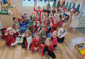 Na zdjęciu widać dzieci i Św Mikołaja który wręcza prezenty.