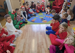 Na zdjęciu widać dzieci i Św Mikołaja który wręcza prezenty.