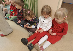 Na zdjęciu widać dzieci i Św Mikołaja który wręcza prezenty.