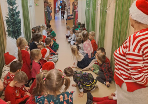 Na zdjęciu widać dzieci i Św Mikołaja który wręcza prezenty.