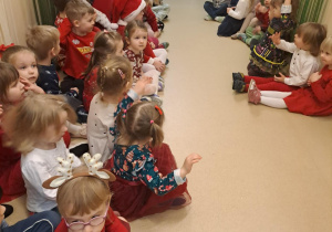 Na zdjęciu widać dzieci i Św Mikołaja który wręcza prezenty.