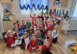 Na zdjęciu widać dzieci i Św Mikołaja który wręcza prezenty.