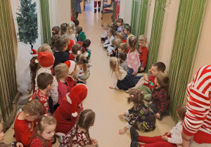 Na zdjęciu widać dzieci i Św Mikołaja który wręcza prezenty.