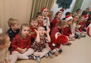 Na zdjęciu widać dzieci i Św Mikołaja który wręcza prezenty.