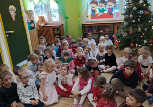 Na zdjęciu widać dzieci przy wspólnym kolędowaniu.